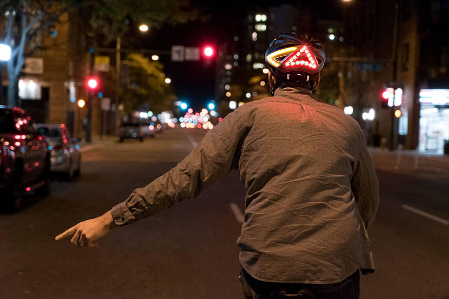 Cycliste qui utilise le clignotant gauche de son casque lumineux Be Mojoo
