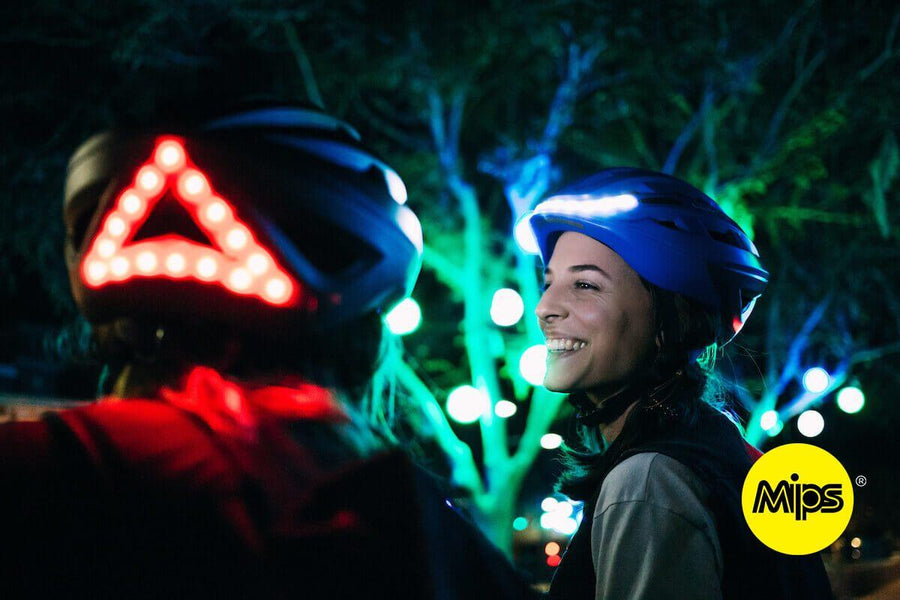 adeptes du vélo de nuit en discussion avec casque lumineux Be Mojoo avec technologie MIPS allumé 